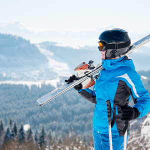 Person resting on snowy mountain wearing ski jacket made with durable functional fabric
